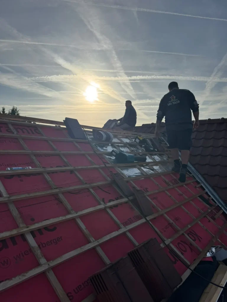 Couvreurs au travail sur une toiture en rénovation