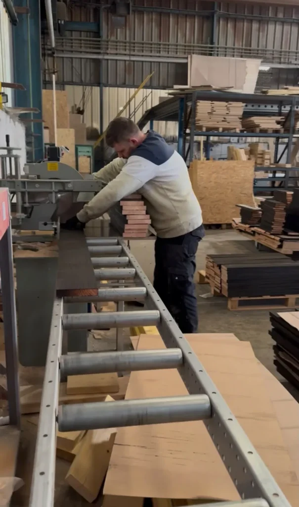Opérateur sur une scie à format dans un atelier de menuiserie